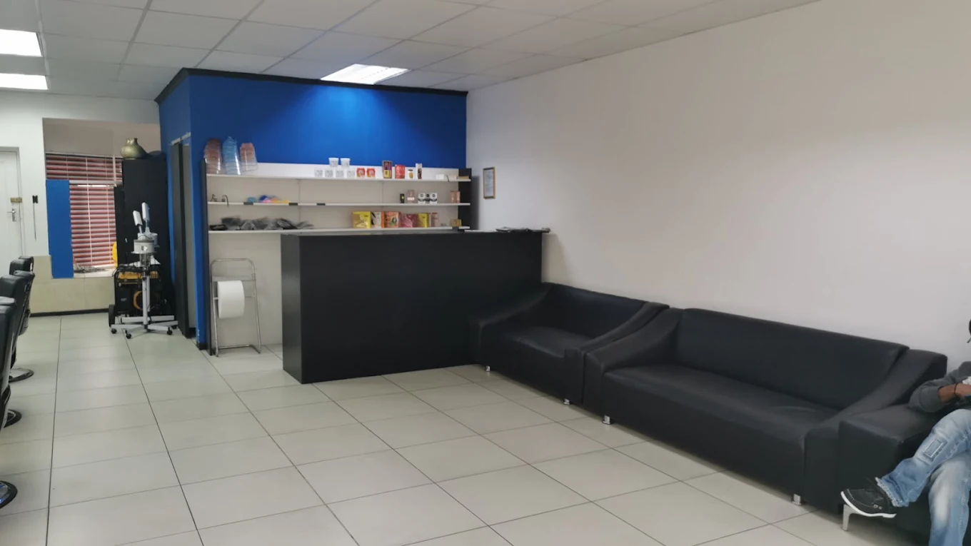 Waiting area with black leather couches and a blue feature wall