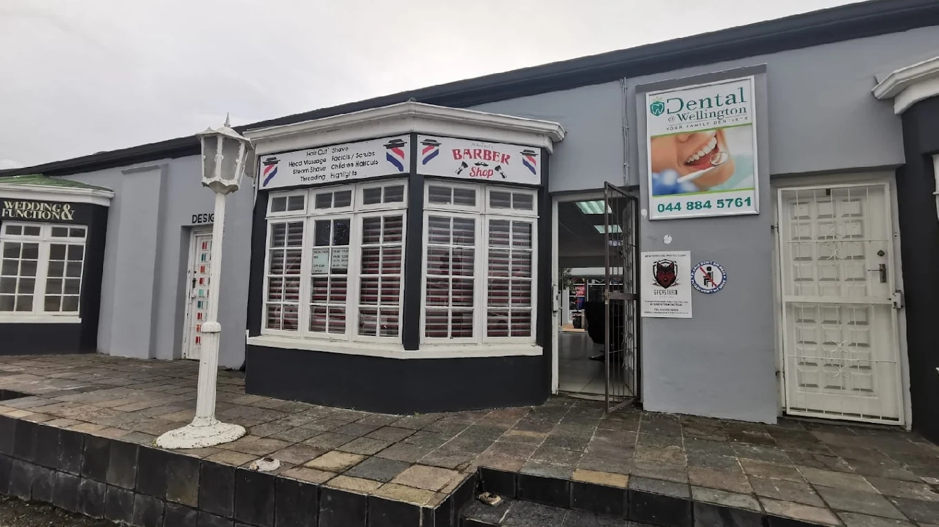 Bay window entrance with signs listing haircuts, shaves, threading and facials