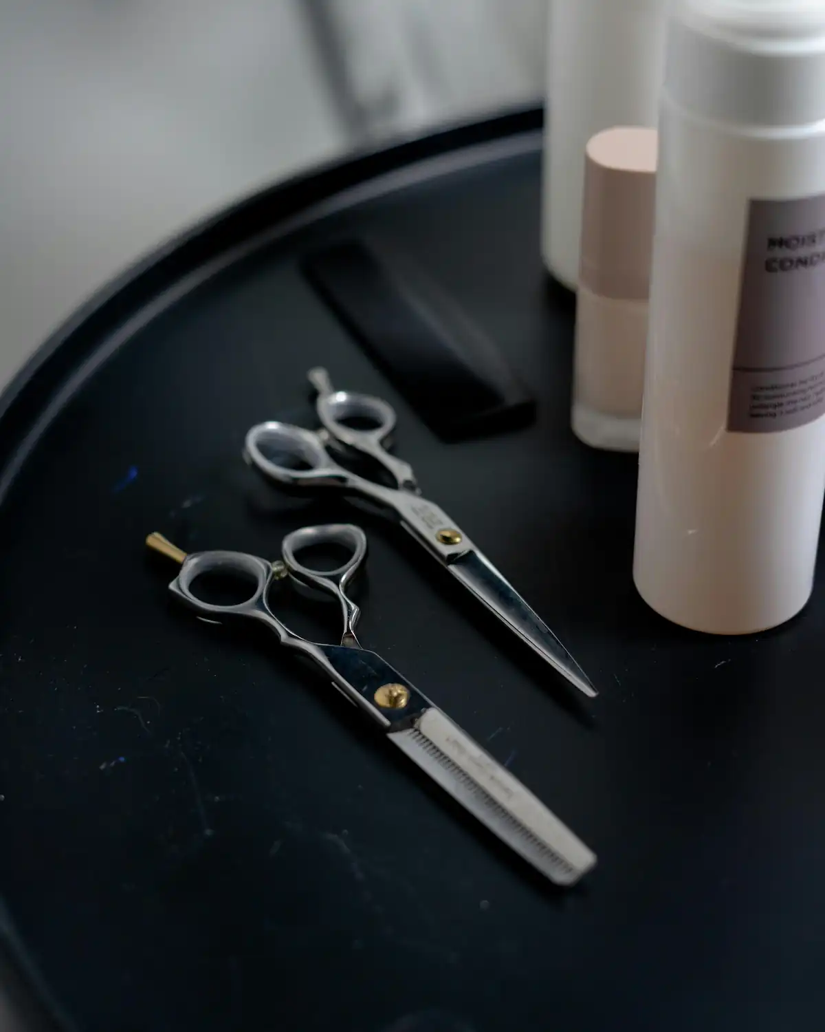 Cutting and thinning scissors on a dark tray