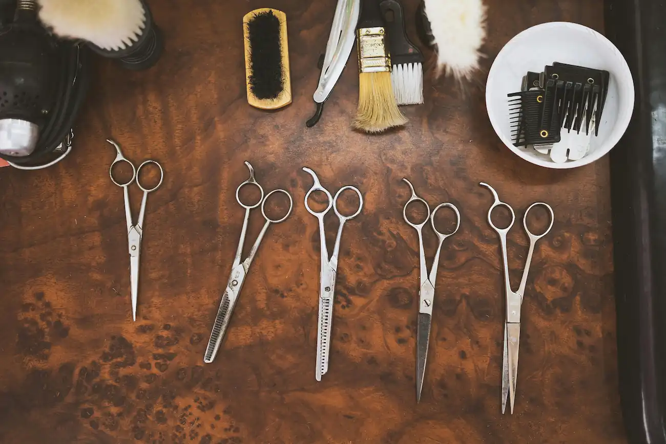 Scissors and brushes laid out on a wooden counter